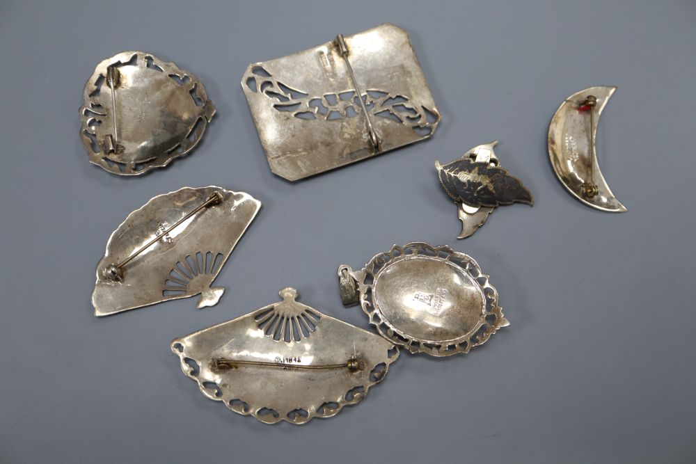 Five assorted Thai sterling and niello brooches, a pair of similar ear clips and a pendant.